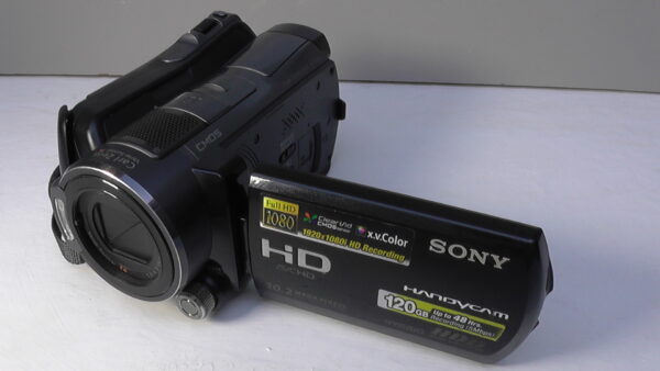 filmadora sony hdr-sr12 usada com anel pequeno multifuncional para controle rápido de ajustes manuais.